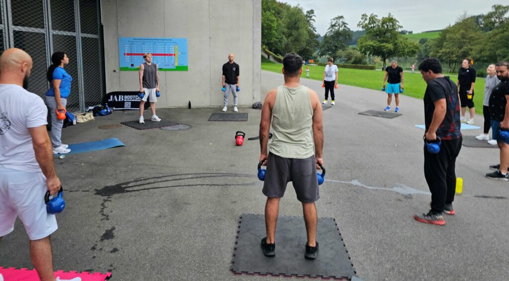 Fitnessstudio oder Gruppentraining Teilnehmer trainieren gemeinsam mit Kettlebells beim JAB Sports Bootcamp in Luzern – funktionelles Gruppentraining mit persönlicher Betreuung.